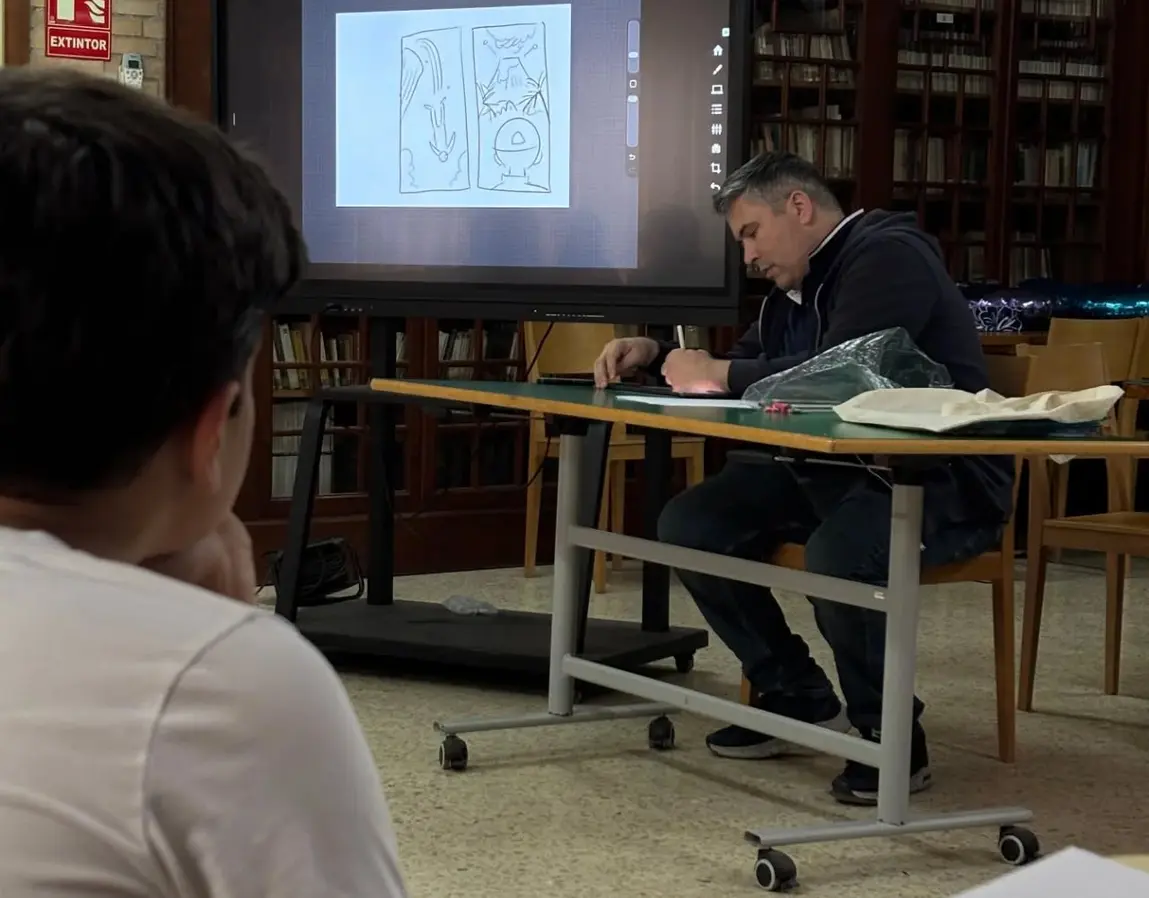 Jape explica una página de cómic ante el grupo