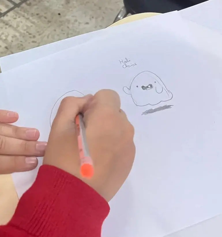 Manos dibujando un personaje durante el taller